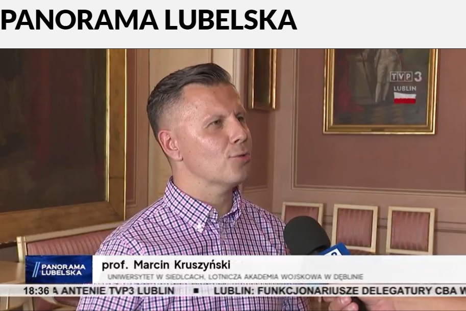 Mezczyzna w koszuli w kratke przed mikrofonem