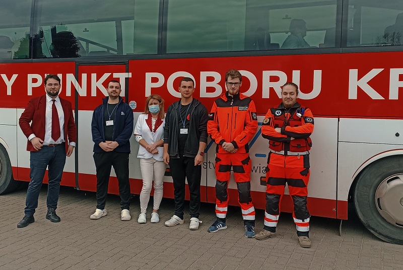 szesc osob stoi przed specjalistycznym autobusem